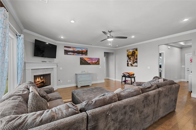 living room featuring hardwood / wood-style flooring, ceiling fan, and ornamental molding