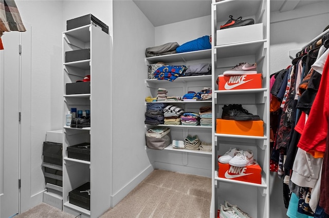 walk in closet featuring light colored carpet