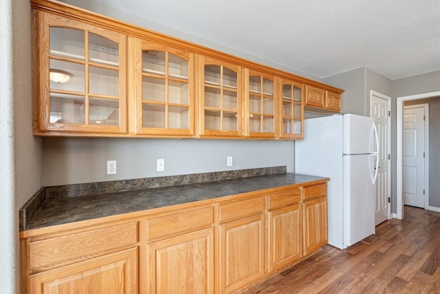 kitchen featuring white fridge, dark hardwood / wood-style flooring, and a textured ceiling