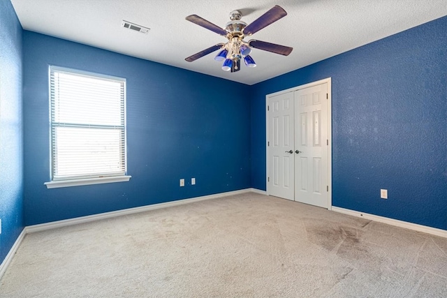 unfurnished bedroom with carpet floors, a closet, multiple windows, and ceiling fan