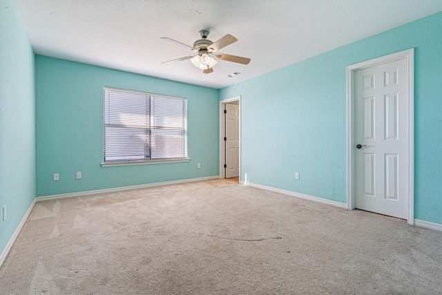 unfurnished room featuring light carpet, a textured ceiling, and ceiling fan