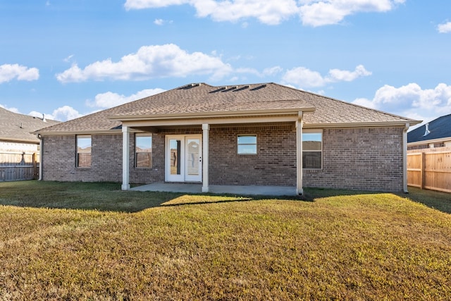 back of property with a yard and a patio