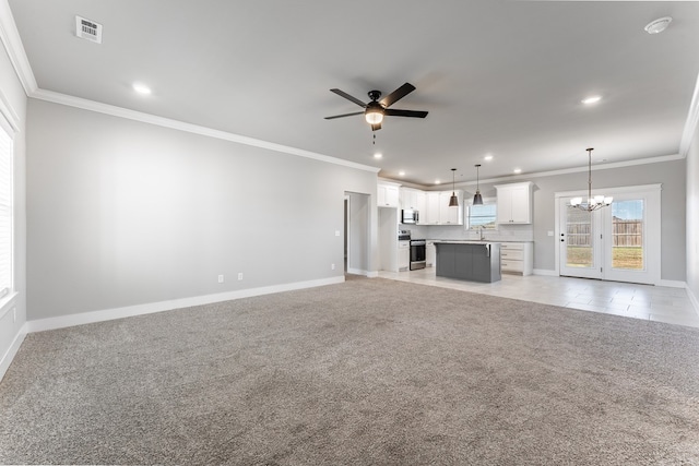 unfurnished living room featuring ceiling fan with notable chandelier, light colored carpet, and crown molding