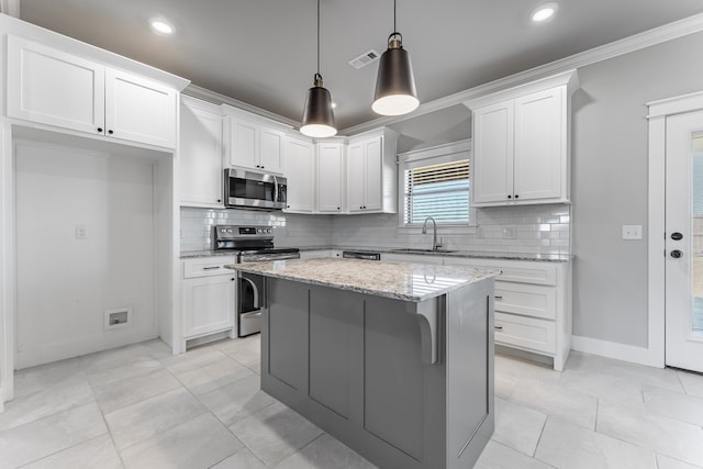 kitchen with white cabinetry, hanging light fixtures, light stone countertops, and appliances with stainless steel finishes