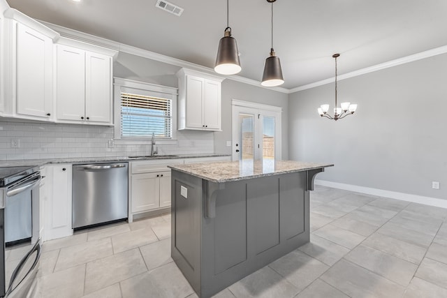 kitchen featuring sink, appliances with stainless steel finishes, decorative light fixtures, a kitchen island, and white cabinetry