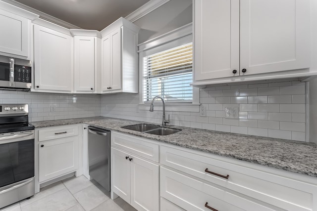 kitchen featuring decorative backsplash, appliances with stainless steel finishes, light stone countertops, sink, and white cabinets