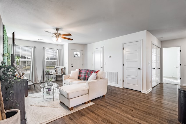 living room with ceiling fan and dark hardwood / wood-style flooring