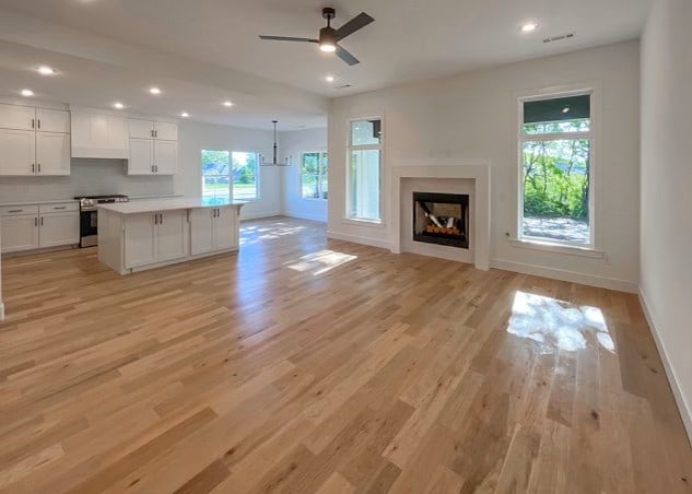 unfurnished living room with ceiling fan and light wood-type flooring