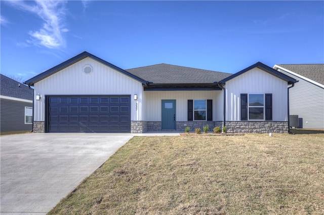 view of front of property featuring cooling unit, a garage, and a front yard