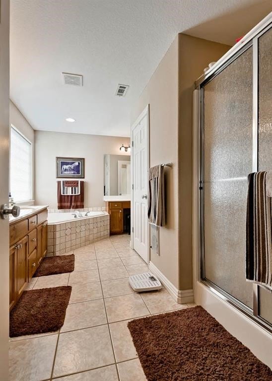 bathroom with separate shower and tub, tile patterned flooring, vanity, and a textured ceiling