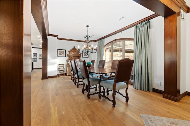 dining area with a chandelier, crown molding, and light hardwood / wood-style floors