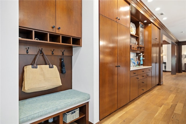 mudroom featuring ornamental molding and light wood-type flooring