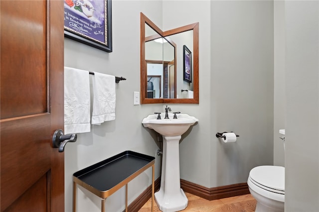 bathroom featuring hardwood / wood-style floors and toilet