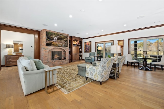 living room with crown molding, a fireplace, and light hardwood / wood-style floors