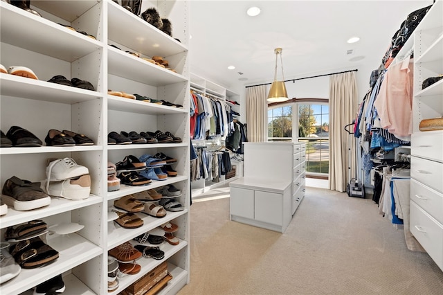 walk in closet featuring light colored carpet