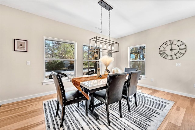 1433 S Duncan Ave, Fayetteville, AR 72701 - dining space with healthy amount of natural light, baseboards, light wood-style flooring, and a chandelier