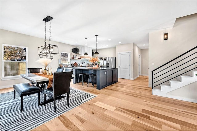 1433 S Duncan Ave, Fayetteville, AR 72701 - dining area featuring light wood-type flooring, stairs, baseboards, recessed lighting, and a chandelier