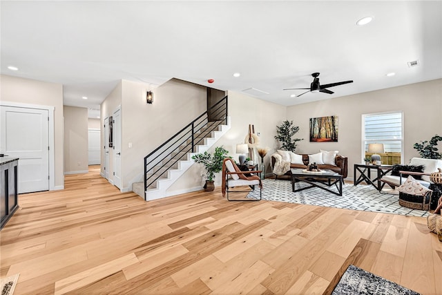 living room with ceiling fan and light wood-type flooring