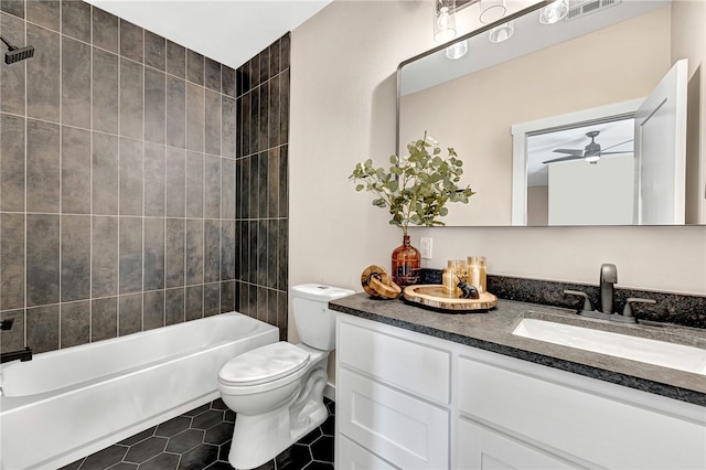 full bathroom featuring tiled shower / bath, tile patterned floors, toilet, and vanity