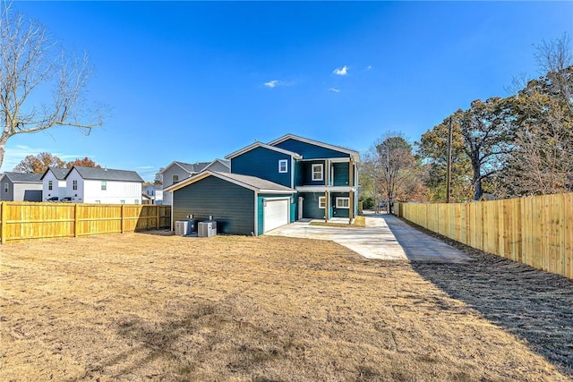 1433 S Duncan Ave, Fayetteville, AR 72701 - rear view of property with driveway, cooling unit, a fenced backyard, and an attached garage