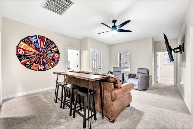 carpeted living room with ceiling fan