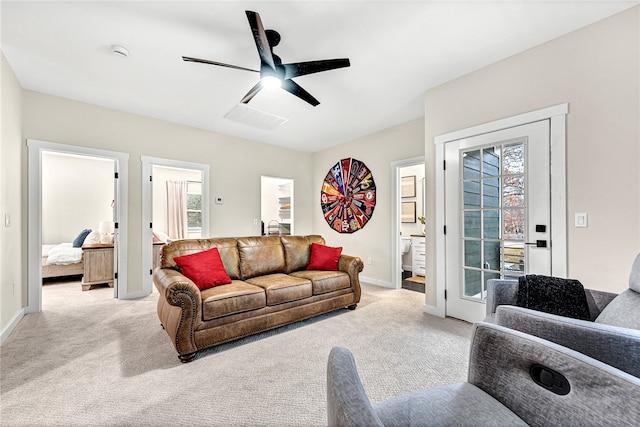 living room featuring plenty of natural light, light colored carpet, and ceiling fan