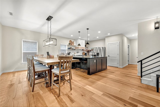 dining space featuring sink and light wood-type flooring