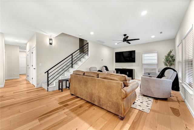 living room with light hardwood / wood-style floors and ceiling fan