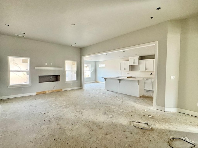 unfurnished living room featuring a fireplace and baseboards