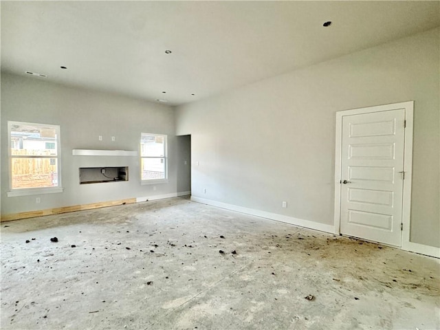 unfurnished living room with visible vents, a fireplace, and baseboards