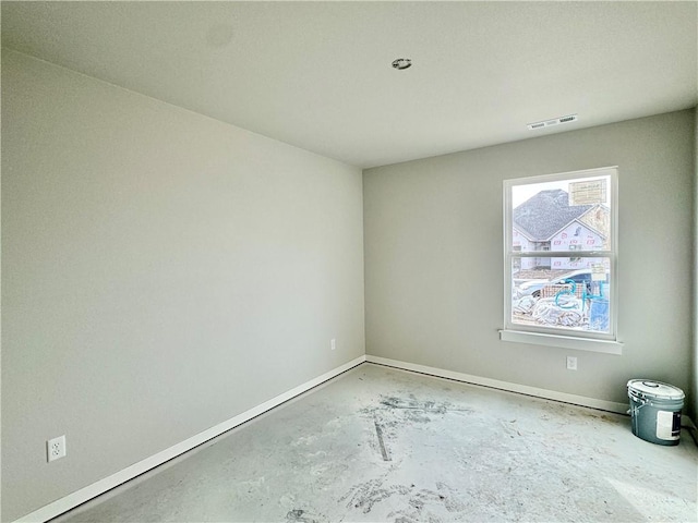 spare room featuring baseboards, unfinished concrete floors, and visible vents