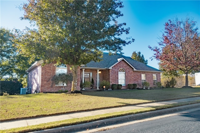 single story home featuring a front lawn and central air condition unit