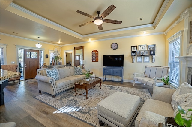 living room featuring a wealth of natural light, wood-type flooring, and ornamental molding