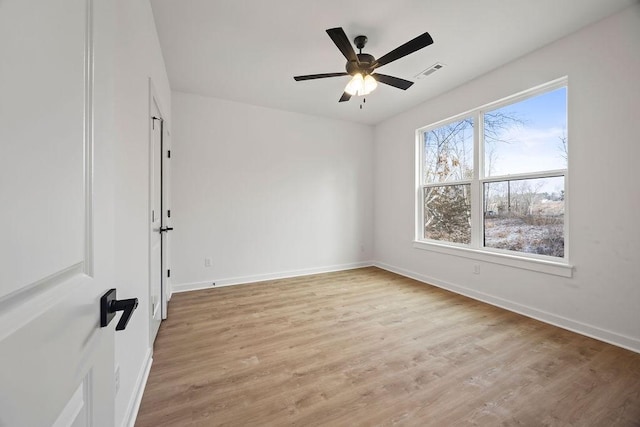 unfurnished room with a ceiling fan, visible vents, light wood-style flooring, and baseboards