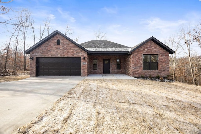 single story home featuring an attached garage, concrete driveway, and brick siding