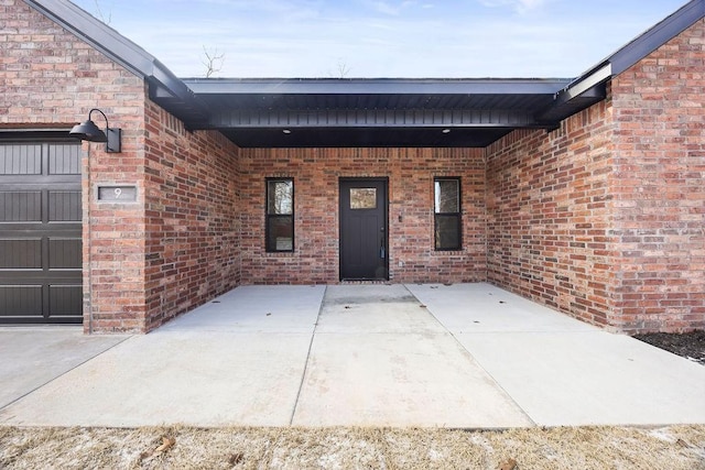 view of exterior entry with brick siding