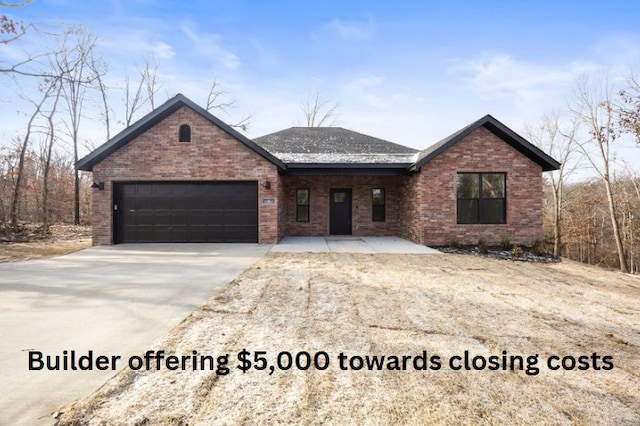 ranch-style home with concrete driveway, brick siding, and an attached garage