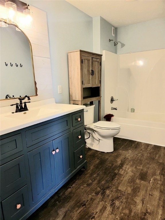 full bathroom with shower / tub combination, vanity, hardwood / wood-style flooring, and toilet