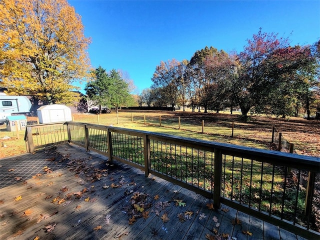 deck featuring a storage unit and a yard