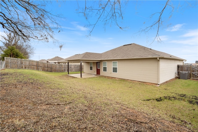 rear view of property featuring a yard, a patio, and central air condition unit