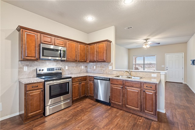 kitchen featuring a textured ceiling, dark hardwood / wood-style flooring, sink, and appliances with stainless steel finishes