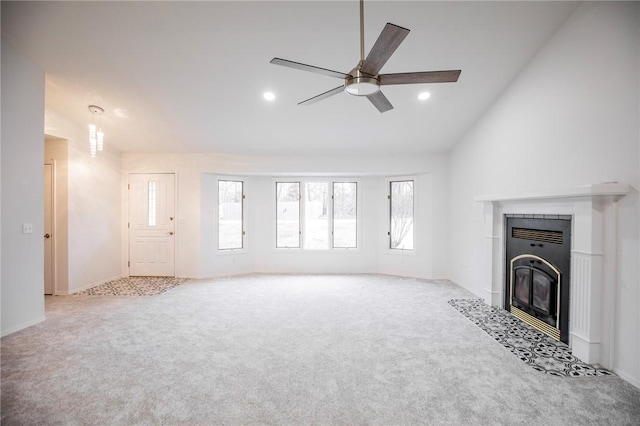 unfurnished living room featuring a tiled fireplace, ceiling fan, light carpet, and vaulted ceiling