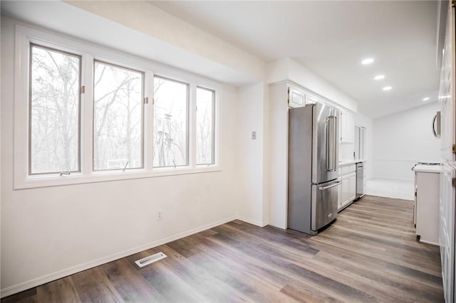 kitchen with hardwood / wood-style floors, white cabinetry, plenty of natural light, and stainless steel appliances