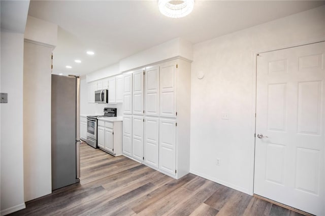 kitchen with white cabinets, light wood-type flooring, and appliances with stainless steel finishes