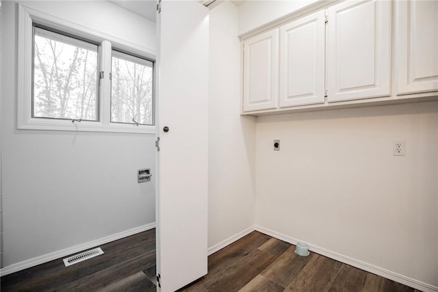 laundry room featuring electric dryer hookup, dark hardwood / wood-style flooring, and cabinets