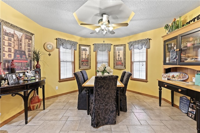 dining room featuring a textured ceiling, ceiling fan, a healthy amount of sunlight, and light tile patterned flooring