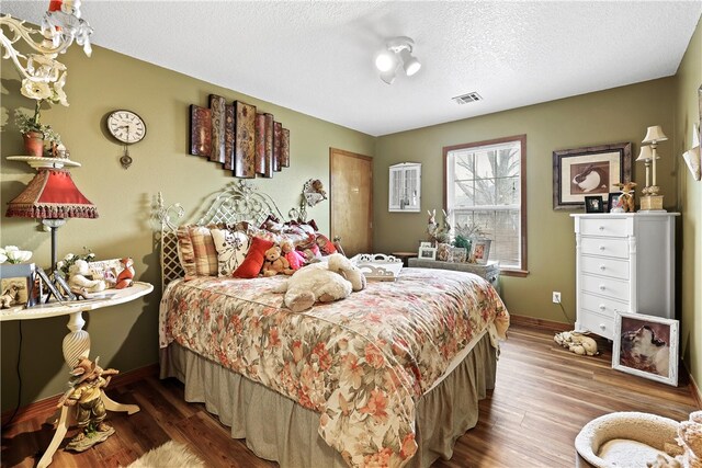 bedroom featuring a textured ceiling and hardwood / wood-style flooring