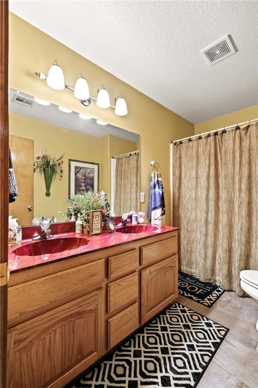 bathroom featuring vanity, toilet, and a textured ceiling