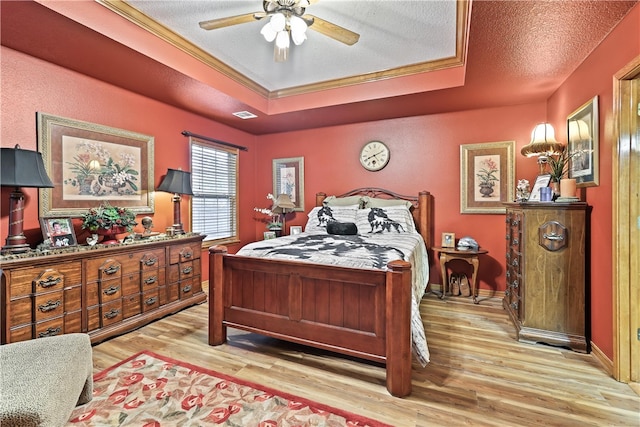 bedroom featuring ceiling fan, light hardwood / wood-style floors, and a textured ceiling