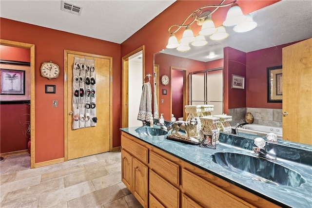 bathroom featuring a bathing tub, vanity, and a textured ceiling